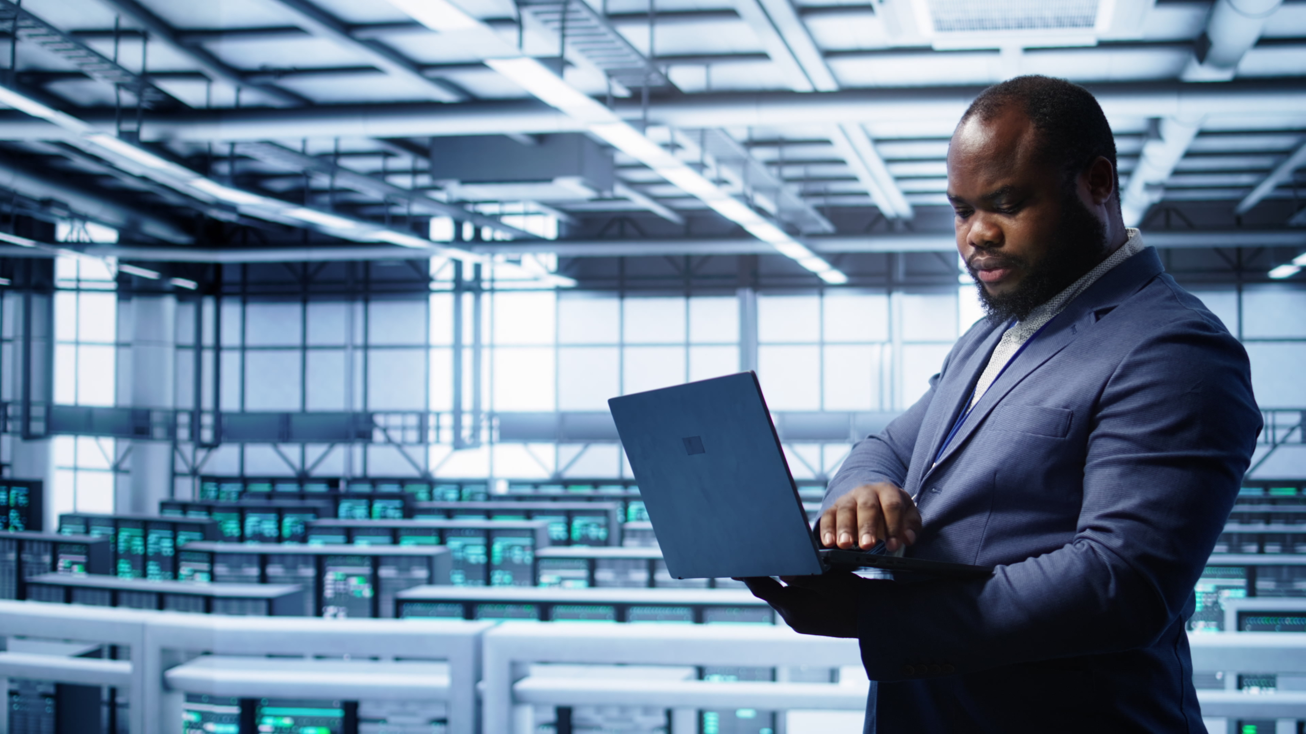 IT professional in server hub monitoring server mainframes using notebook